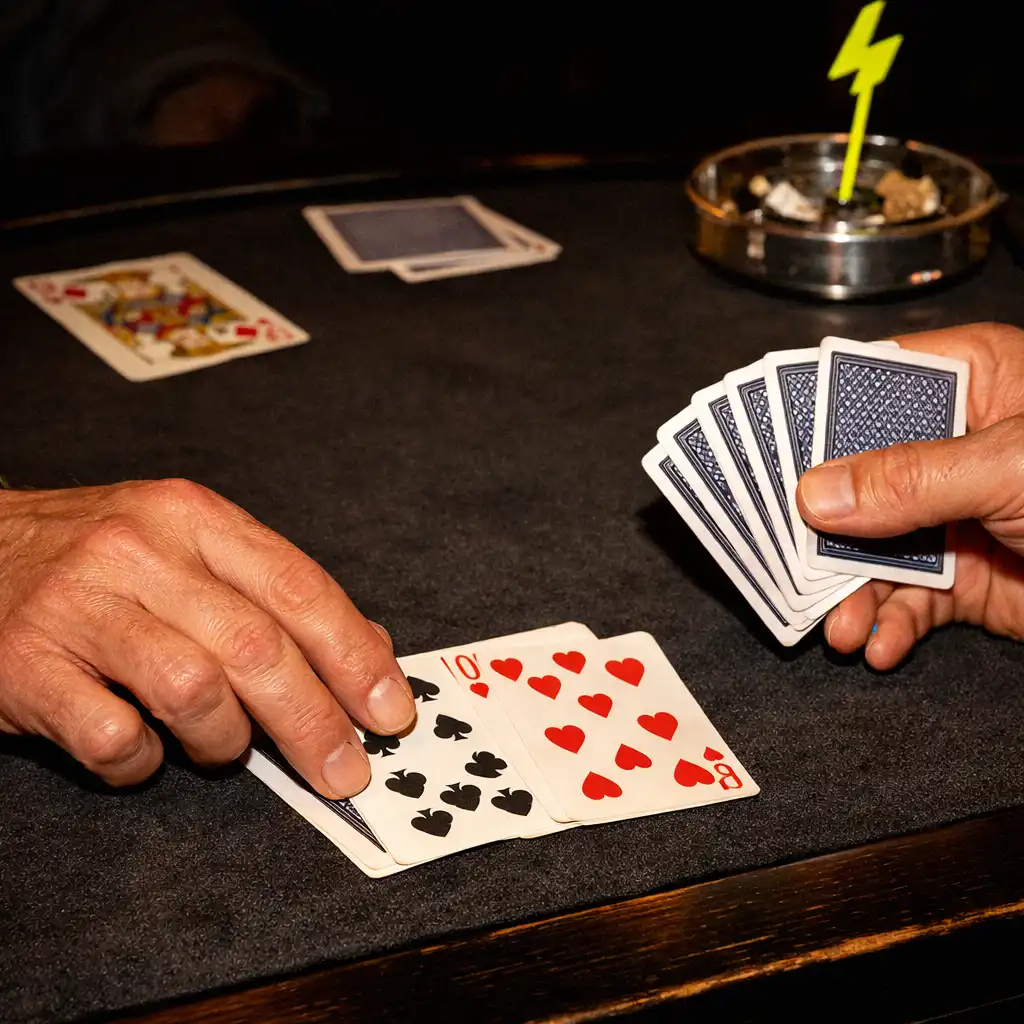 Mains disposant des cartes sur un tapis de table sombre